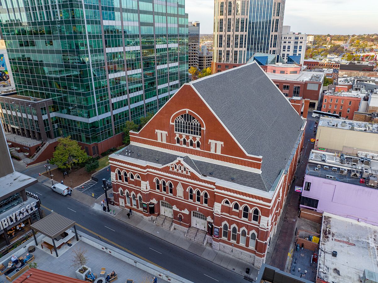 A historic building with a prominent arched entrance and a steeply pitched roof.