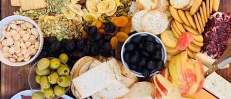 Een charcuterieplank met verschillende kazen, vleessoorten, fruit en noten.