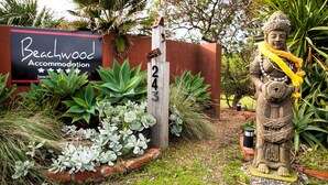A wooden sign with the name 'Beachwood Accommodation' and the number '243'. -  BEACHWOOD STUDIO-a perfectly styled getaway for couples BEACH AT YOUR DOORSTEP (Smiths Beach)