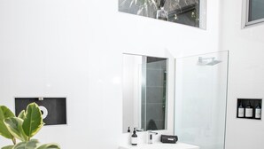 A modern bathroom with a glass shower enclosure, a white bathtub, and a sink with a mirror above it. -  BEACHWOOD STUDIO-a perfectly styled getaway for couples BEACH AT YOUR DOORSTEP (Smiths Beach)
