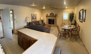 A compact living space with a kitchenette, a dining area, and a fireplace.