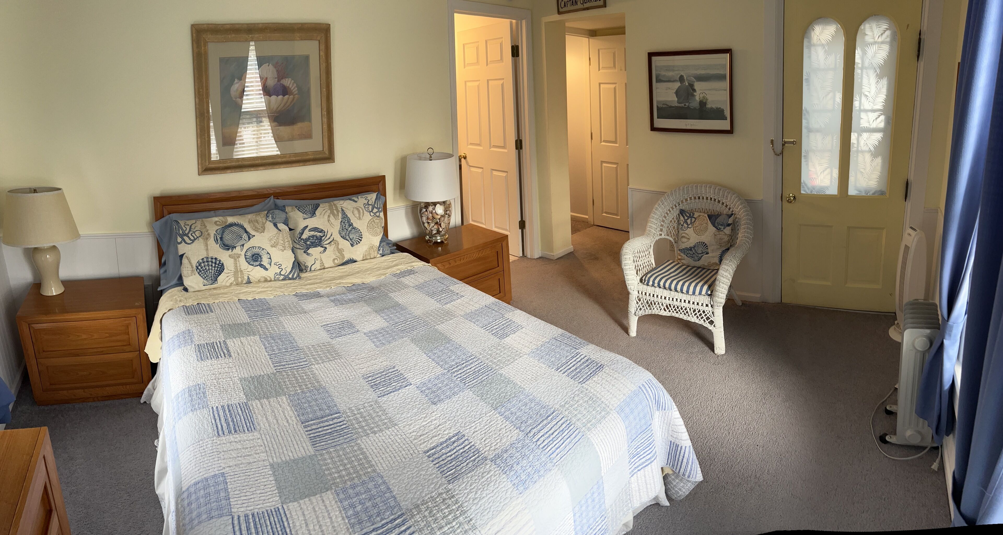 A bedroom with a bed, nightstands, a chair, and a door.