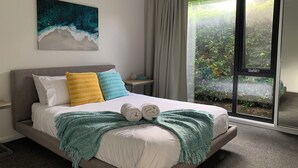 A neatly made bed with white linens, two pillows, and a teal throw blanket. - Premium Waterfront - Jervis Bay Area (St Georges Basin)