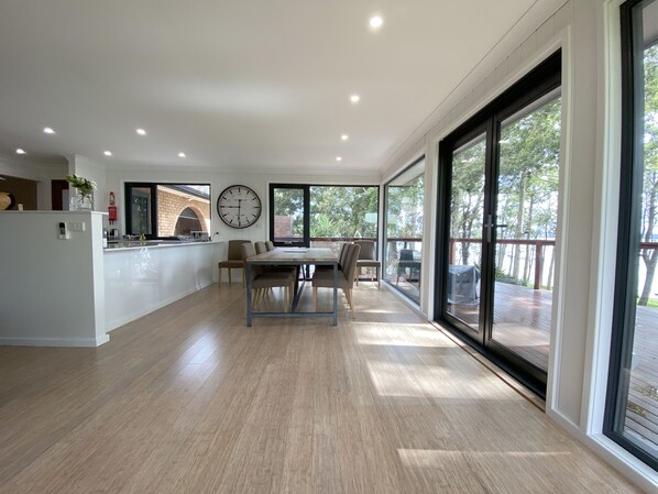 A spacious kitchen with a dining area, large windows, and a view of the outdoors.