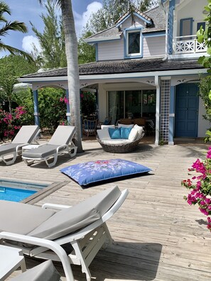 A poolside area with lounge chairs and a covered seating area. - 2 bedrooms, private pool and sea view (Orient Bay)