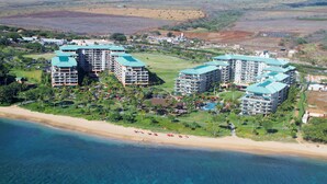 Ein Resort mit mehreren Hochhäusern, einem Strandzugang und einem Golfplatz.