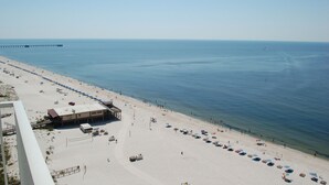 Une plage avec une jetée, des parasols et un poste de surveillance pour les sauveteurs.