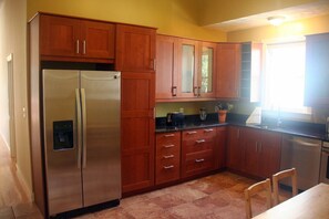 A kitchen with wooden cabinets, a stainless steel refrigerator, a toaster, and a sink. - 2 bedrooms with air-conditioning, parking, laundry, WiFi near Sam Adams & subway (Boston)
