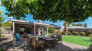 A patio with outdoor furniture, a barbecue grill, and a well-maintained lawn. - Quiet Scottsdale Retreat ~ 3BR ~ FirePit, Garage, EV Charging ~ Prime Location (Scottsdale)
