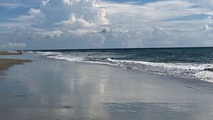 Une plage dotée d’un large rivage sablonneux et de vagues douces.