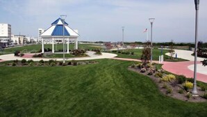 A gazebo with a blue roof and white walls, surrounded by a well-maintained lawn and a curved pathway. - FEEL THE FUN!! BEACH/OCEAN FRONT Clean & Modern 3-BR w/ Pool, Direct Ocean Views (Wildwood Crest)