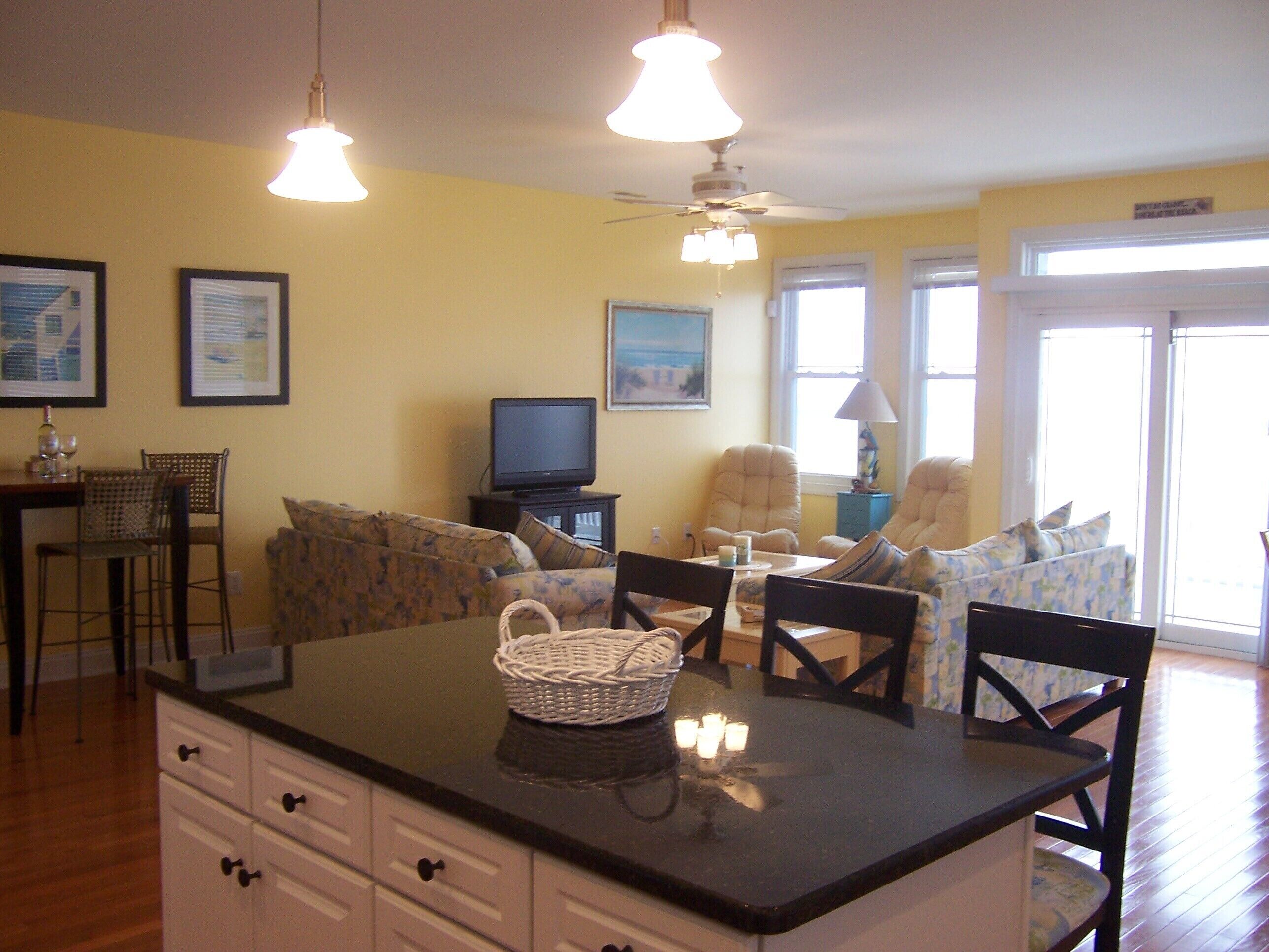 A cozy living area with a sofa, chairs, a television, and a dining table.