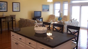 A cozy living area with a sofa, chairs, a television, and a dining table. - FEEL THE FUN!! BEACH/OCEAN FRONT Clean & Modern 3-BR w/ Pool, Direct Ocean Views (Wildwood Crest)