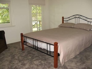 Une chambre avec un lit simple, une fenêtre et une vue sur la verdure.