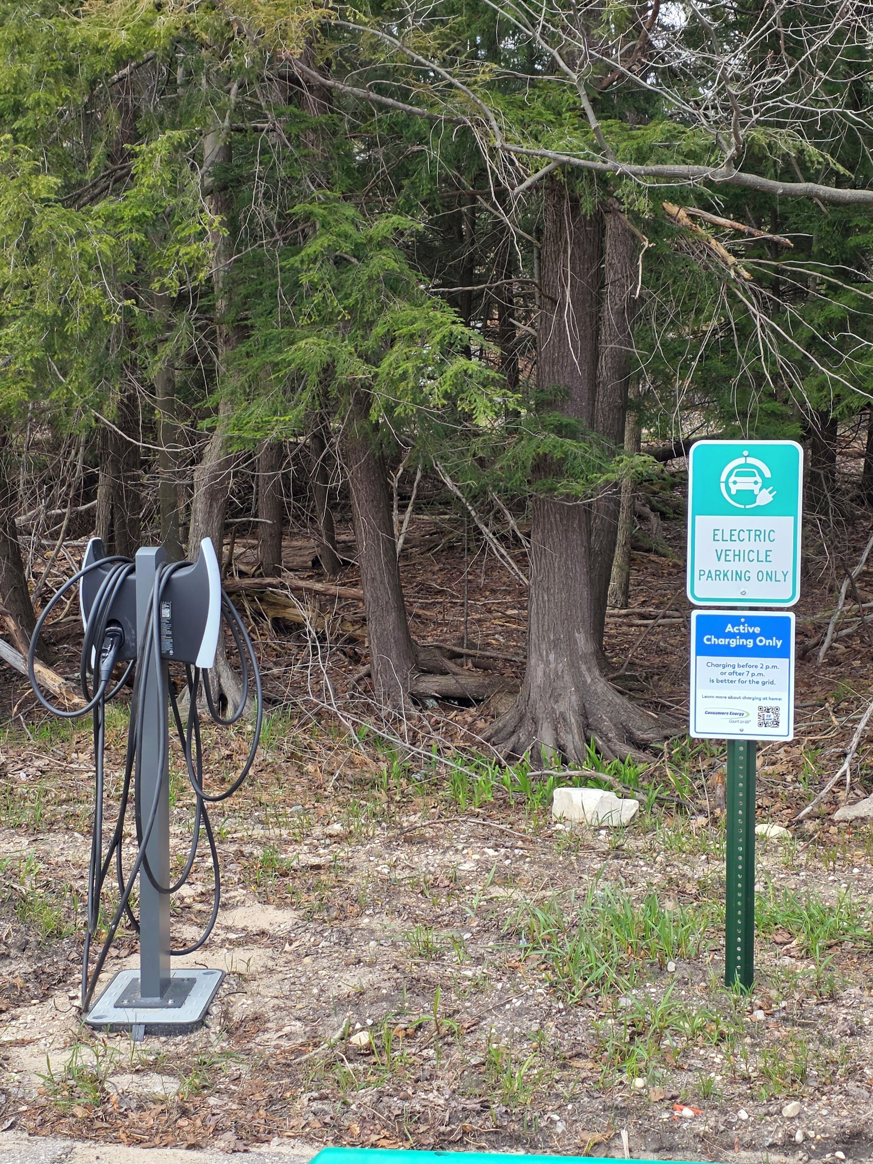 An electric vehicle charging station with a sign indicating it is for electric vehicles only and active charging only.