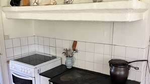 A compact kitchen with a white stove, oven, and black countertop.