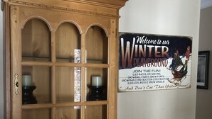 Un meuble en bois doté de plusieurs portes en verre et une affiche sur le mur faisant la publicité d’un parc de jeux d’hiver.
