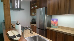 A modern kitchen with wooden cabinets, stainless steel appliances, and a tiled backsplash. - Immaculate Updated Condo, 5 Minutes from Skiing!  (Wilson)