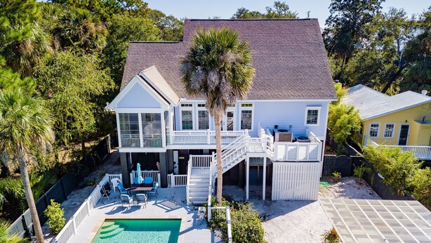 A two-story house with a pool, deck, and outdoor seating area. - Sand Castle | Heated Saltwater Pool, Game Room & Walk to Beach and Center Street (Folly Beach)