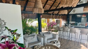 A cozy outdoor seating area with wicker furniture and a thatched roof.