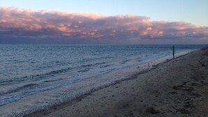 Una playa con cielo despejado y mar tranquilo.