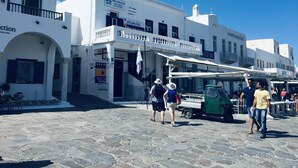 A white building with multiple signs, including 'Blue Star Ferries' and 'IATA'. - Mykonos Old Harbor Front Suite with Balcony  (Mikonos)