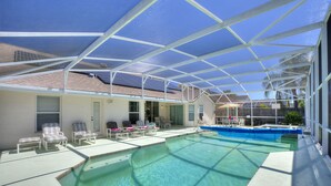 A covered outdoor swimming pool with lounge chairs and a patio area. - Secluded Luxury Pool Home, Close to Disney w/ Oversized pool  Special offers now (Kissimmee)