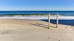 A beach with a wooden structure, possibly a lifeguard station, and the ocean in the background. - OCS4 Semi-Ocean-Front Home with Gorgeous Views (Nags Head)