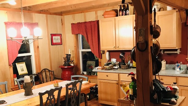 Ein gemütliches Holzinterieur mit Essbereich, Küche und einem Fenster mit Vorhängen.