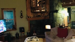 Ein gemütliches Wohnzimmer mit Kamin, Fernseher und bequemen Sitzmöglichkeiten.