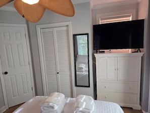 A bedroom with a bed, a television, a wardrobe, and a door. - Cooper Flats-Upstairs - 2 blocks to the Beach & to Downtown FB, Extraordinary! (Folly Beach)