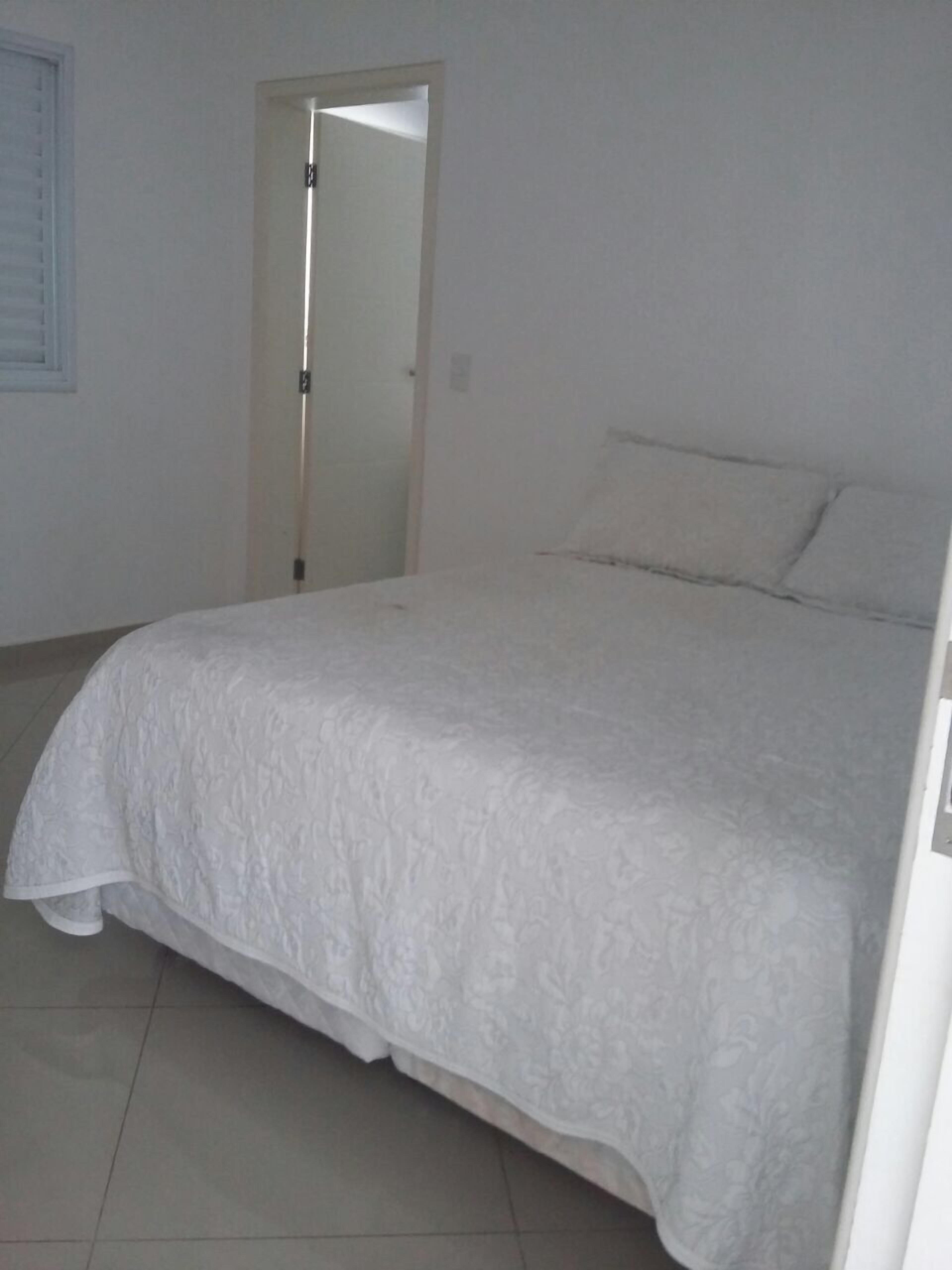 Une chambre à coucher avec un lit, une porte et un sol carrelé.