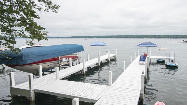 A dock with boats, a kayak, and umbrellas. - 3 BR/2 BA House just steps from Lake Geneva (Williams Bay)