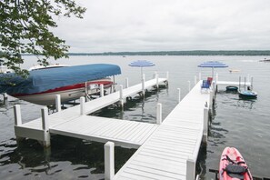 A dock with boats, a kayak, and umbrellas.
