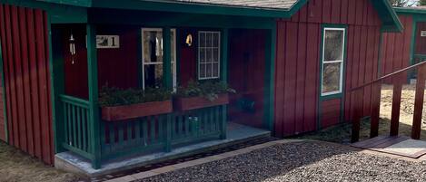 A red building with a green porch, a number '1' sign, and a small window.