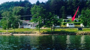 Une propriété au bord du lac, comprenant une maison, des arbres et un quai.