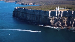 A coastal cliff with a white building on top, overlooking a body of water. - Unit 6 - Modern Studio Huskisson main street By Nautilus Apartments Jervis Bay (Huskisson)