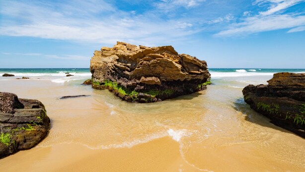 A rocky outcrop surrounded by sandy beach with clear blue sky. - Spirit Level Mallacoota (Mallacoota)