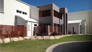 A modern two-story house with a garage, a stone retaining wall, and a well-maintained lawn. - Gillian's on the beachfront Port MacDonnell, the best view in town. (Port MacDonnell)