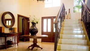 Una scala con ringhiera in legno e pavimento lucido che conduce a una porta.