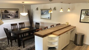 Een moderne keuken met een centraal eiland, een houten eettafel en stoelen.