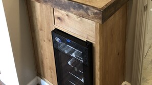 Een compacte keuken met een inbouwvaatwasser, een spoelbak en een lichtschakelaar op de muur.