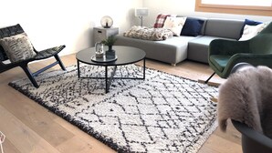 En moderne stue med en sofa, et sofabord og en lænestol.
