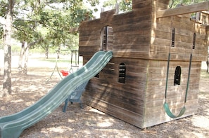 Kids can play and climb on this outdoor play structure resembling a ship's cabin.