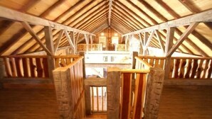 An attic room with a wooden ceiling and a central wooden beam structure. - Lake Buchanan Lodge featuring optional Pavilion with free kayaks and canoes. (Buchanan Dam)