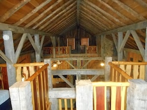Staircase leads to an upper level in this charming space with a high ceiling and wooden beams.