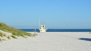A beach with a lifeguard tower and a clear blue sky. - White beaches, walk to restaurants and shops! Family vacation /Romantic getaway! (Clearwater)
