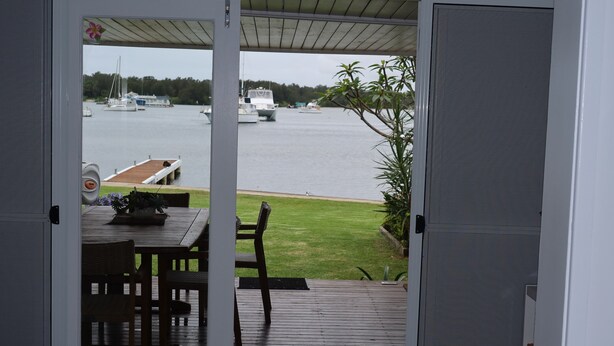 A view from a room with a wooden deck overlooking a body of water with boats. - Ducks Bungalow- Lake Macquarie (Marks Point)