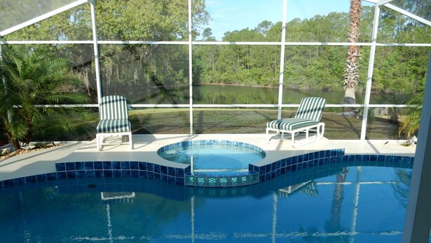 A swimming pool with two chairs and a view of a lake. - Private Pool + Heated Hot Tub | Lake View (Davenport)