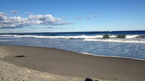 A beach with waves, a clear sky, and a distant shoreline. - Beautiful Roomy Beach House...See and Hear the Ocean Waves (Wells)